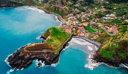 Fototapeta premium Aerial view of rough ocean with waves, volcanic beach in Porto da Cruz, Madeira, Portugal