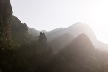 su beams through the mountain cliffs in Vang Vieng, the adventure capital of Laos