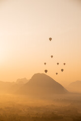 Obraz premium hot air balloons rising at golden sunrise in the mountain valley in Vang Vieng, the adventure capital of Laos