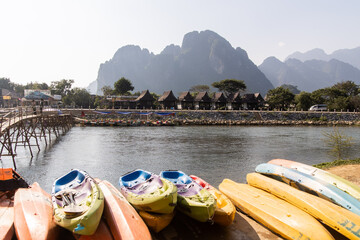 kayaks parked on the dock of the river in Vang Vieng, the adventure capital of Laos