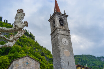 Italy, Varenna, 22.04.2024: Church of Chiesa di Santa Maria delle Grazie against a backdrop of rocks and petrified trees