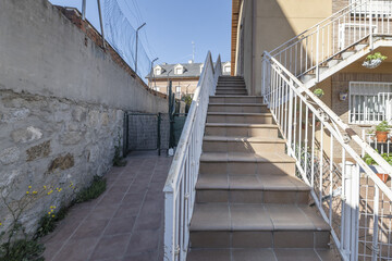 Terracotta metal stairs with white railings in a residential apartment building