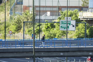 Obraz premium a pedestrian traveling on an overpass saving a large road junction