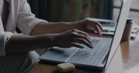 Close-up of female hands typing with laptop computer while programmer working at software development at home. Modern technology and IT person concept.