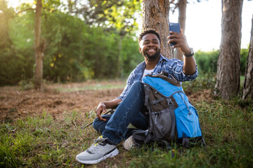 Young hiker taking selfie  while enjoys resting in nature.