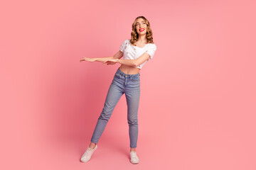 Full length photo of pretty cute girl wear white top jeans look at proposition empty space dance...