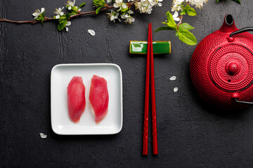 Tuna sushi adorned with cherry blossom branch and chopsticks, epitomizing Japanese food culture