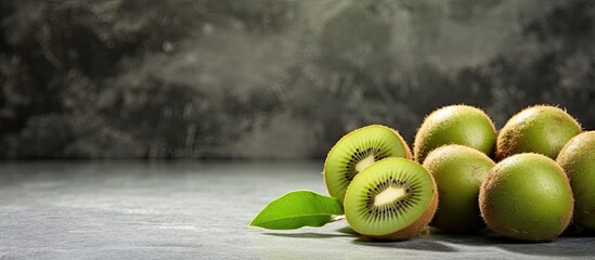 A copy space image showing kiwi fruits placed on a textured stone background