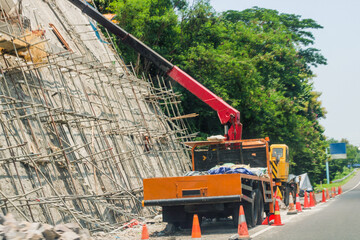 Toll road cliff casting using heavy equipment