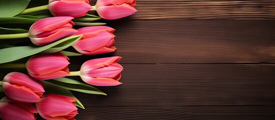 A beautiful arrangement of tulips is placed on a wooden table creating an appealing border design It is perfect for a copy space image