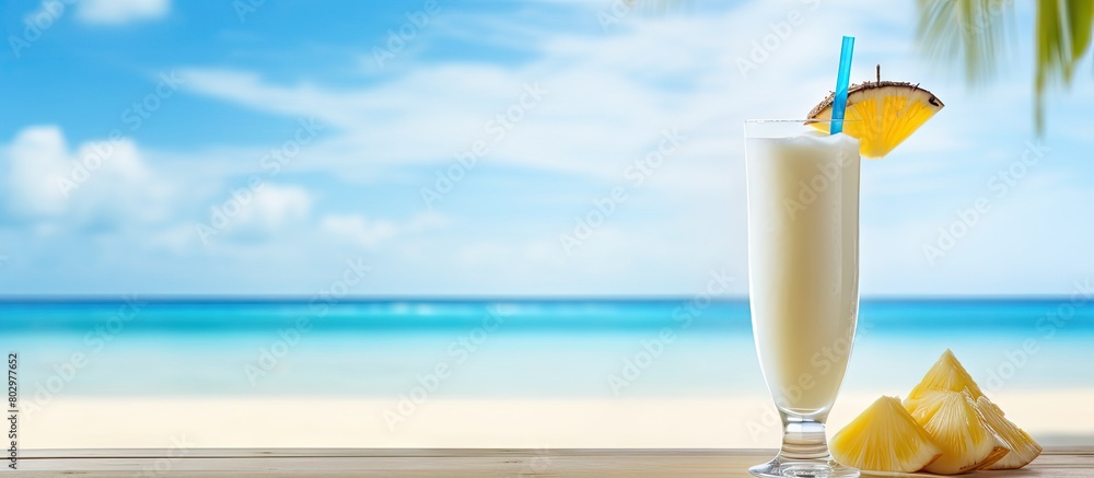 Poster a delicious pina colada cocktail placed on a wooden table with the mesmerizing ocean backdrop provid