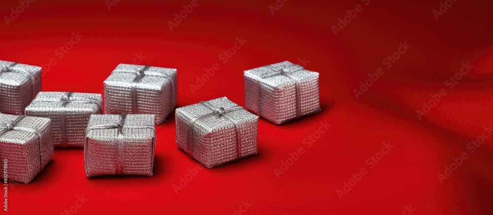 Poster a charming scene of small silver square gift boxes adorns a backdrop of red knitted fabric creating 