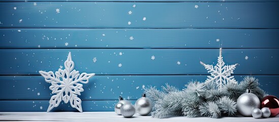 A festive blue and white Christmas composition featuring a star and a Christmas tree on a backdrop of blue wooden planks with copy space image