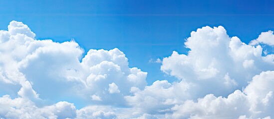 A beautiful blue sky with fluffy white clouds providing a picturesque backdrop for a copy space image