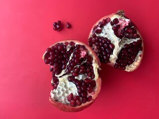 pomegranate fruit in section isolated on red background 