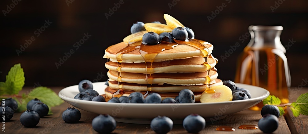 Aufkleber A breakfast of fluffy pancakes topped with banana blueberries and maple syrup displayed on a wooden background with copy space
