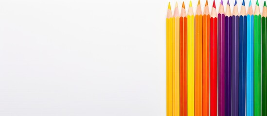 A copy space image featuring colored pencils resembling the LGBT flag placed on a white card Adjacent to it is a multicolored paper flag painted in the colors of the LGBT community