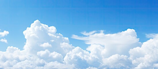 A copy space image showcasing a clear blue sky adorned with fluffy white clouds