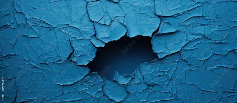 Poster A blue sheet with a torn and worn texture revealing a hole The sheet has a painted surface and offers copy space for text