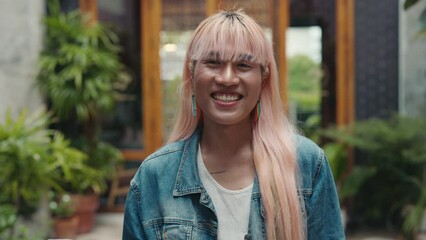 Portrait of an Adorable LGBT Individual with Pink Hair Blowing an Affectionate Air Kiss to the Camera.