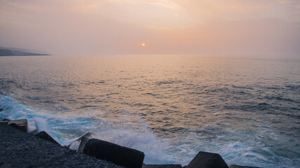 Sunset on the coastline with crashing waves
