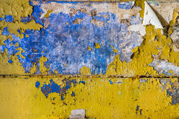 Texture Of An Old Colorful Grunge Blue Wall With Peeling Yellow Paint