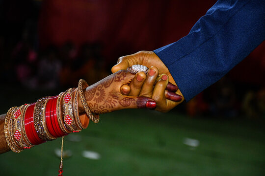Indian wedding hands holding bride and grooms. Indian culture marriage bride hand with beautiful red bangle. ring ceremony before marriage