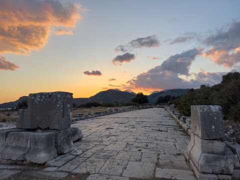 Evening view of the historic ruins of Xanthos, an ancient city and former capital of Lycia, located in Kaş, Antalya, Turkey, under a colorful sunset.