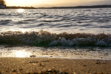 waves on the shore of the lake during sunset