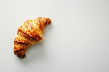 Minimalistic photo of a single croissant on a plain white background, emphasizing the simplicity and beauty of the pastry