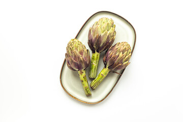 Fresh vegetables - raw artichokes. Green and purple artichoke flower buds