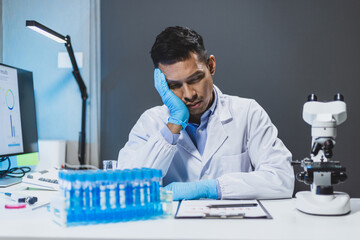 A scientist who is trying in the lab, he is working too hard but is not successful in his...