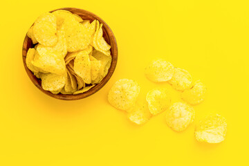 Crisps or potato chips with salt in wooden bowl, top view