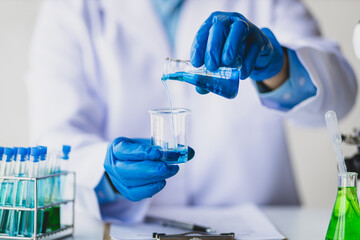 Scientists working in a laboratory are testing solutions in test tubes.