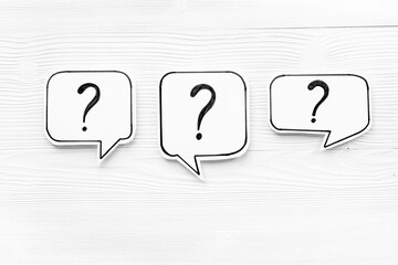 Question marks on paper speech bubbles, top view. Ask and answer concept