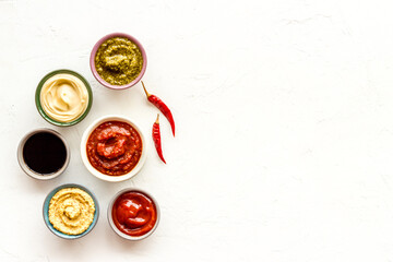 Many different sauces in bowls with spices and chili pepper. Food or cooking background