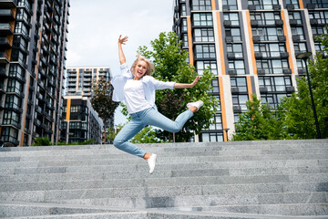 Photo of overjoyed successful girl rent modern apartment flat in big town megapolis jump up spring...