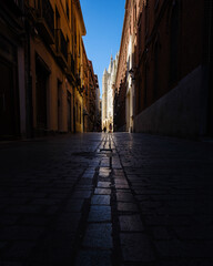 View of a dark street with cobblestones leading to the cathedral of Leon - Spain.