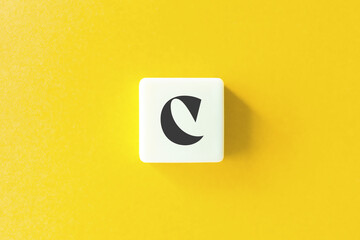 Capital Letter C. Text on Block Letter Tiles against Yellow Background.