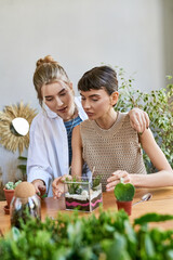 Lesbian couple enjoying a creative moment at a table in an art studio.