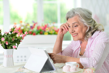 Cute nice senior woman using laptop at home - Powered by Adobe