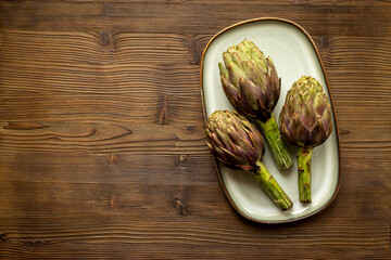 Fresh vegetables - raw artichokes. Green and purple artichoke flower buds