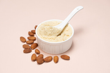 Almond flour and almonds on a beige background