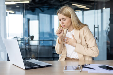 Businesswoman feeling sick while working at her laptop