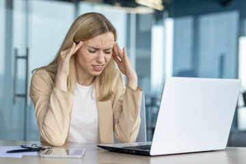 Stressed businesswoman suffering from headache at work
