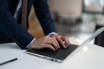 Close up view of businessman typing on laptop
