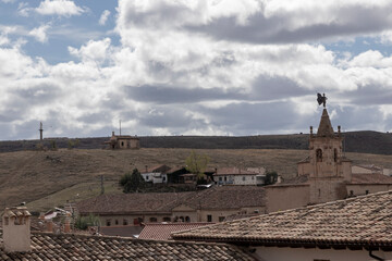 a rustic village under a cloudy sky, highlighting architecture, nature’s beauty, and a serene,...