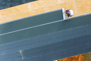 Installing new asphalt bitumen shingles on home roof