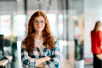 A portrait of a young businesswoman with modern orange hair captures her poised presence in a...