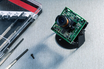 cctv camera service repair concept. modern cctv camera and set of screwdrivers on the desk.